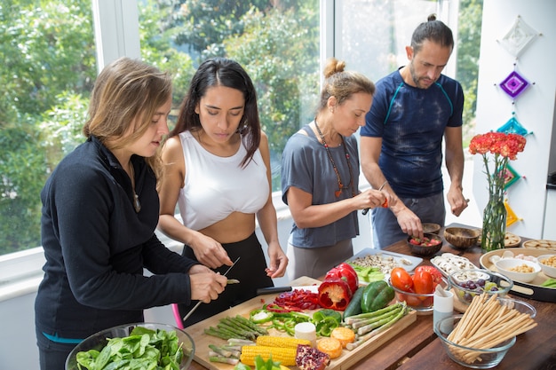 Foto gratuita gente seria che cucina in cucina