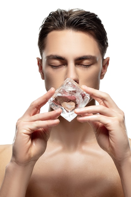 Serious. Portrait of young man isolated on white studio background. Caucasian attractive male model. Concept of fashion and beauty, self-care, body and skin care. Handsome boy with well-kept skin.