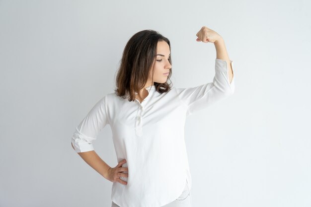 Serious proud girl showing strength gesture.