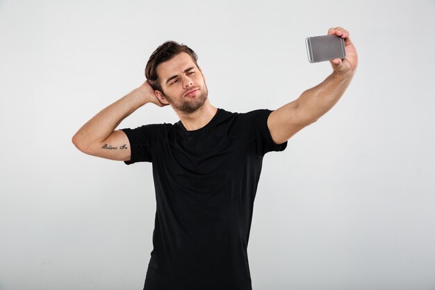 Serious sportsman make selfie by mobile phone