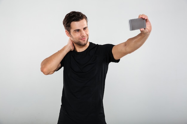 Serious sportsman make selfie by mobile phone