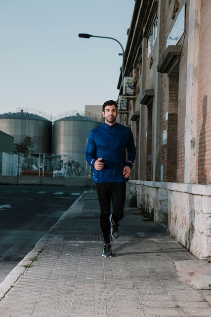 Serious sportsman running on empty street