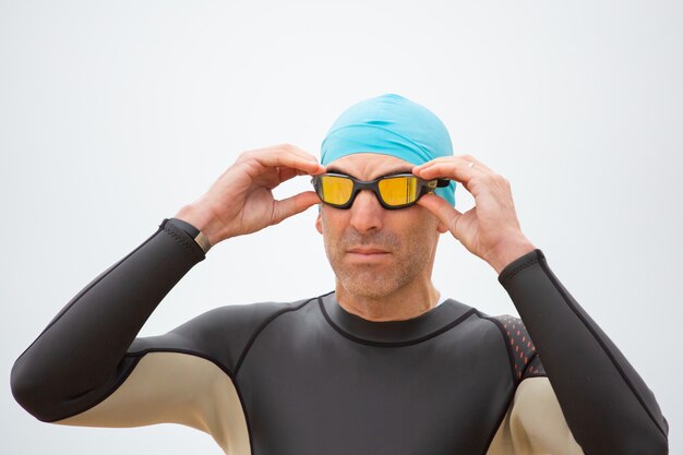 Serious sportsman in wetsuit wearing goggles