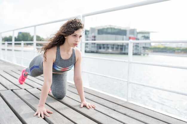 Serious Sporty Girl Exercising on City Quay