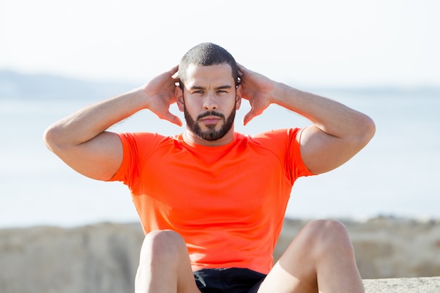 Serious Sporty Strong Man Doing Sit-ups Outdoors