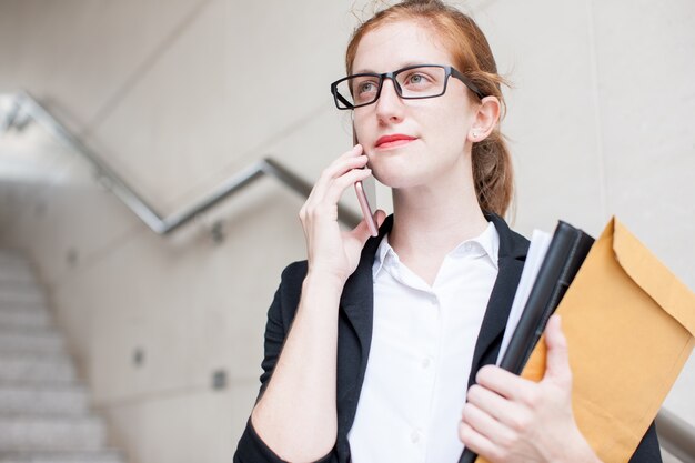 Free photo serious student calling on phone on staircase