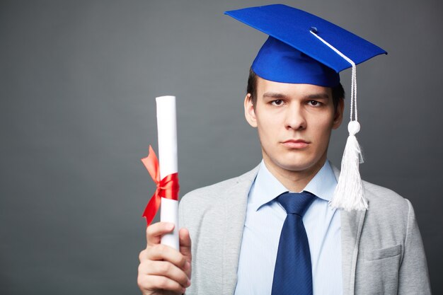 Serious teenager holding his certificate