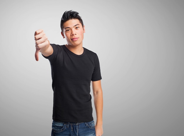 Free photo serious teenager showing thumb down