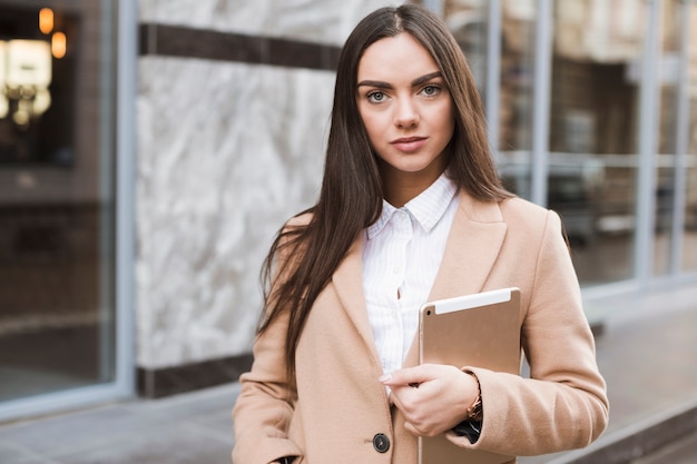 Serious trendy brunette with tablet