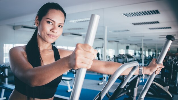 Serious woman doing an elliptical machine