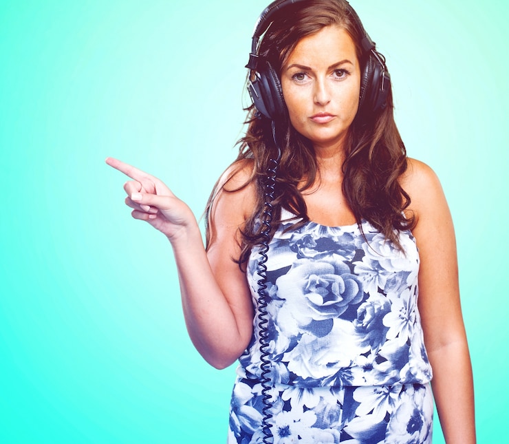 Free Photo serious woman listening to music and pointing to the copyspace
