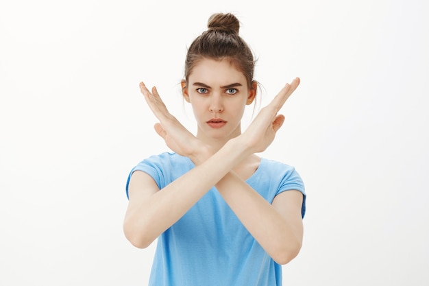 Serious woman making stop cross gesture, rejecting or forbidding something, disapprove action