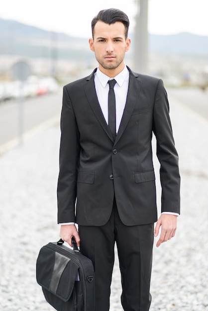 Serious worker holding his briefcase