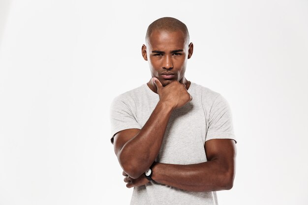 Serious young african man standing isolated