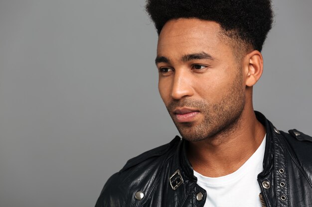 serious young afro american guy with stylish haircut looking aside