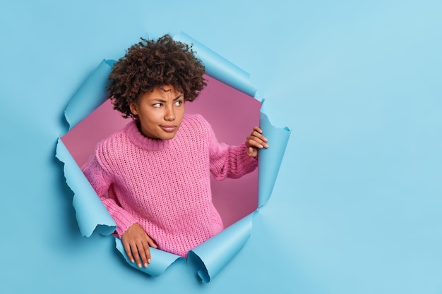 Free photo serious young afro american woman tries to understand something looks away with interest focused right