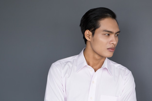 Serious Young Asian Businessman Looking Away