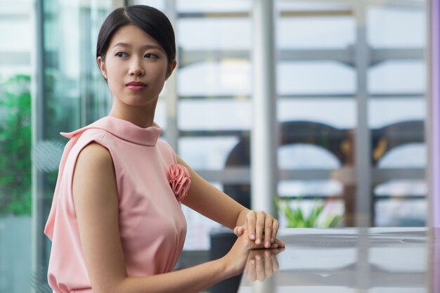 Serious Young Asian Woman Sitting in Cafe