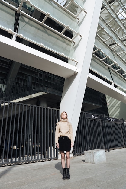 Serious young blonde lady outdoors with eyes closed.