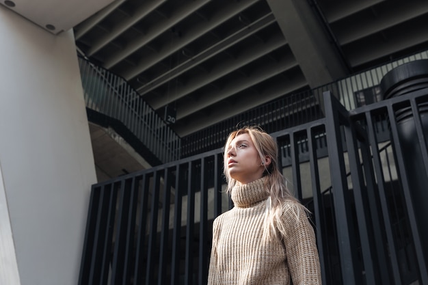 Serious young blonde lady walking outdoors.