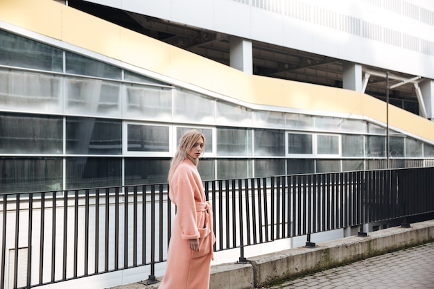 Free photo serious young blonde lady walking outdoors.