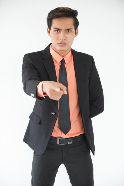 Serious young businessman pointing at camera