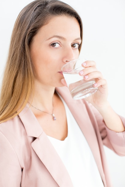 Free photo serious young businesswoman drinking water