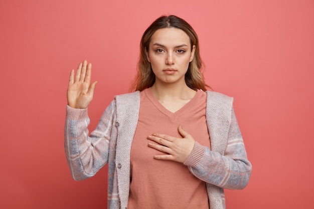 Serious young girl doing promise gesture 