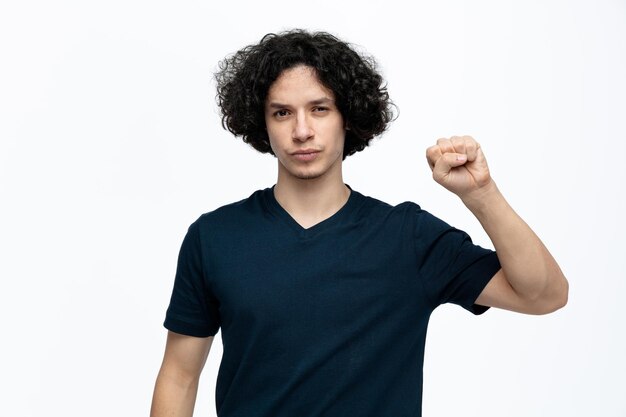 Serious young handsome man looking at camera doing knocking gesture isolated on white background