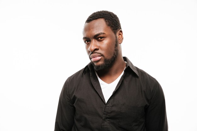 Serious young man dressed in shirt isolated