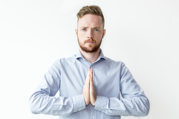 Serious Young Man Keeping Hands Together