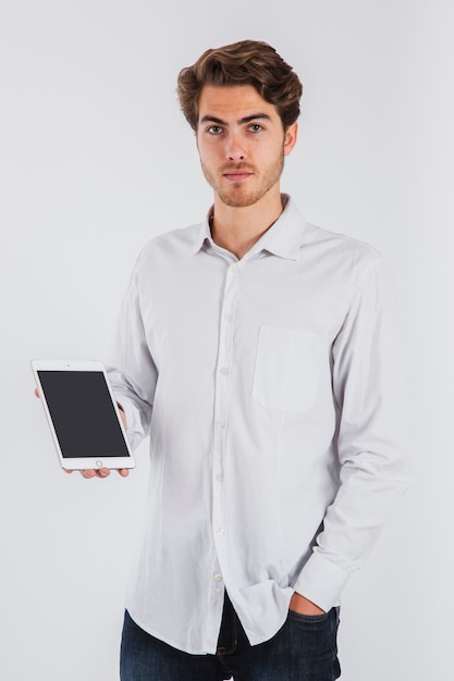 Serious young man posing with tablet