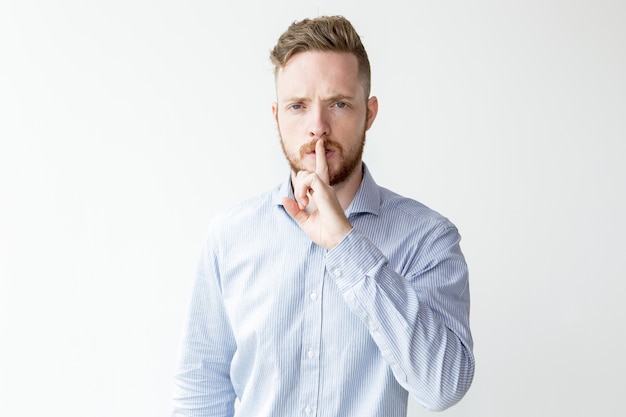 Serious Young Man Showing Silence Gesture