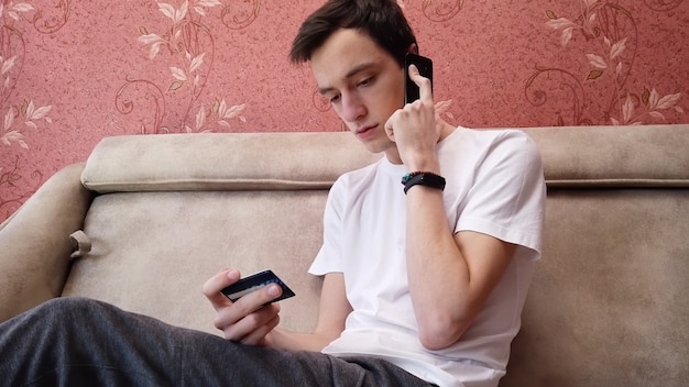 Free photo serious young man talking on phone for online shopping