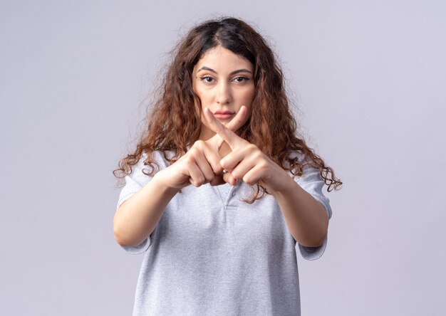 Foto gratuita seria giovane bella ragazza caucasica che non fa gesto isolato sul muro bianco con spazio di copia