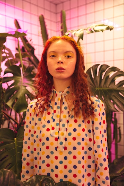 Free photo serious young redhead curly lady standing in cafe near latrine