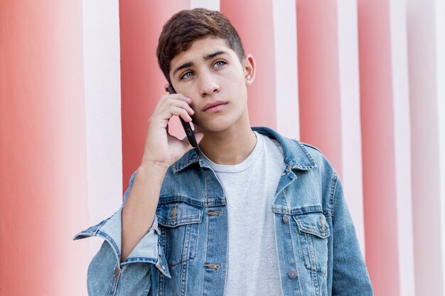 Serious young teenage boy talking on cellphone at outdoors