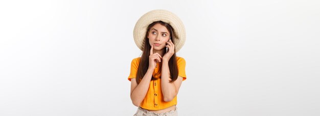 Serious young woman using smartphone and thinking isolated