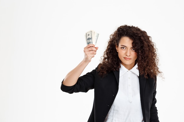 Free photo seriously curly business girl holding money