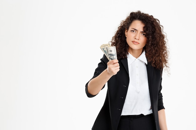 Free photo seriously curly business girl holding money