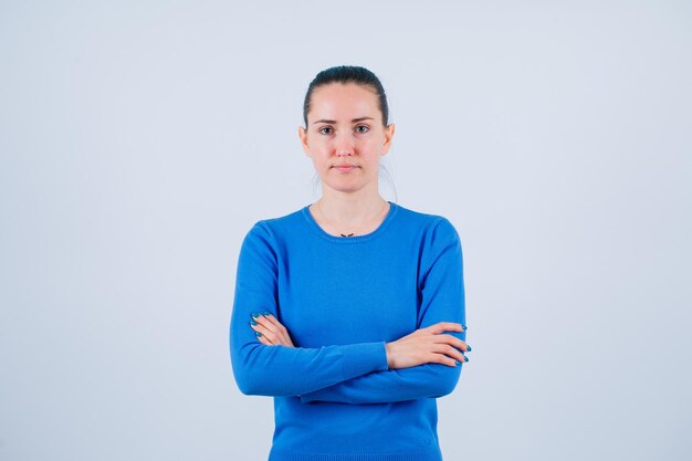 Seriously girl is looking at camera by crossing arms on white background