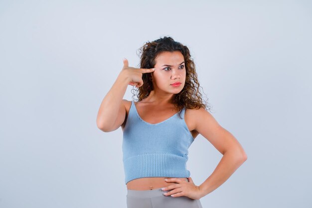 Seriously girl is looking right by holding forefinger on temple on white background