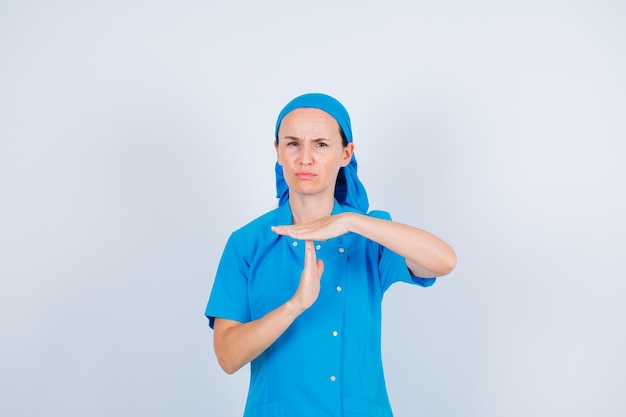 Серьезно медсестра показывает жест рукой на белом фоне