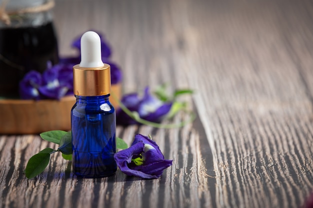 Serum bottle of Butterfly Pea Flower oil put on wooden background