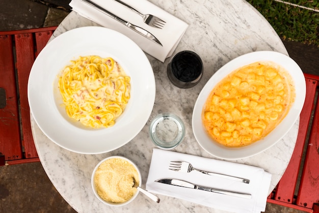 Foto gratuita servi piatti di pasta italiana sul tavolo di marmo nel ristorante