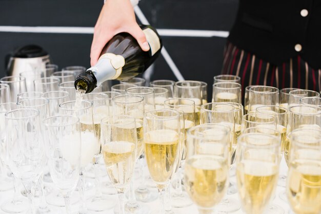 Server filling glasses with champagne