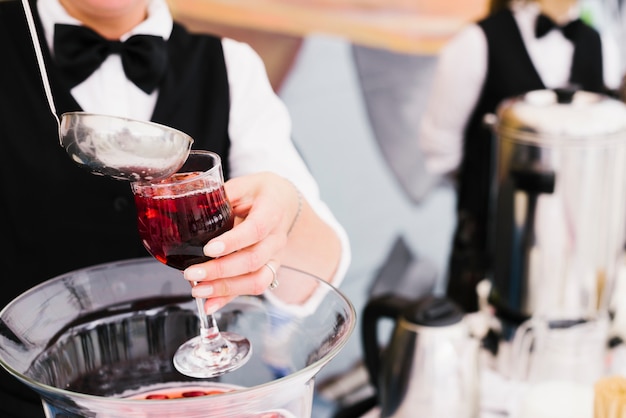 Server pouring sangria with ladle