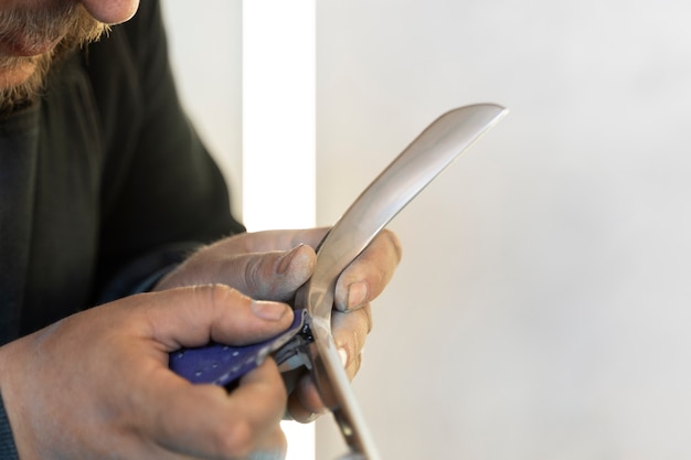 Service worker painting car in auto service