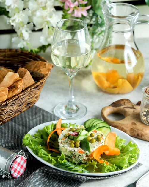 A serving of olivie salad garnished with cucumber decor