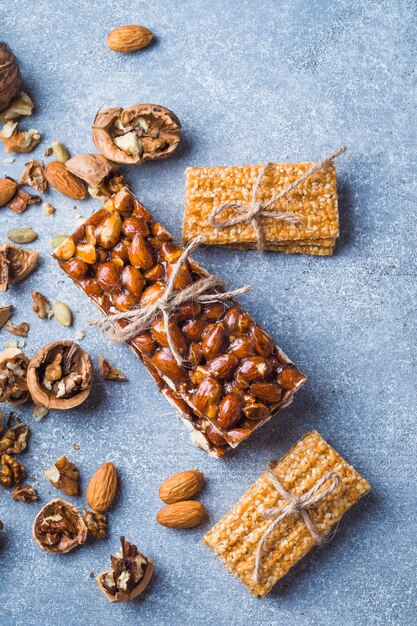 Sesame and almonds healthy bar tied with string on concrete backdrop